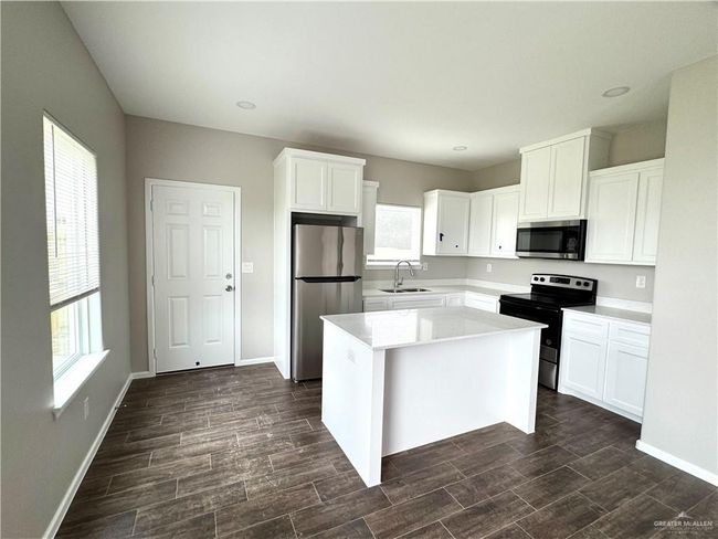 Unfurnished bedroom with dark wood-type flooring, baseboards, a closet, and ceiling fan | Image 4