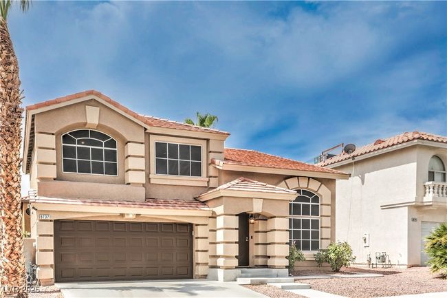 View of front of house with stucco siding, a garage, concrete driveway, and a tile roof | Image 4