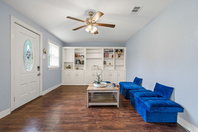 Living area with ceiling fan, vaulted ceiling, and dark wood-type flooring | Image 4