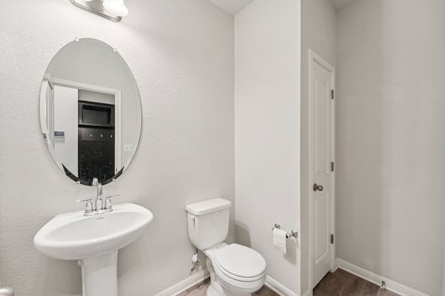 Half bathroom featuring toilet, baseboards, and wood finished floors | Image 8