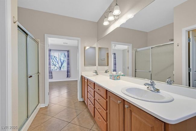 Primary bath with double vanity, walk-in shower stall, and tile patterned floors | Image 15