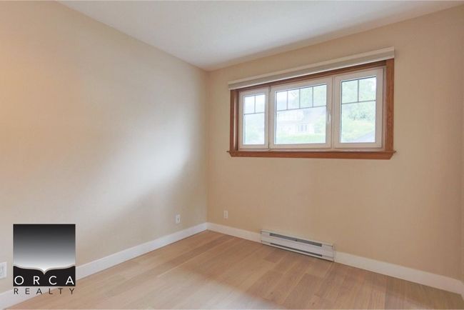 Empty room with a baseboard heating unit and wood finished floors | Image 29