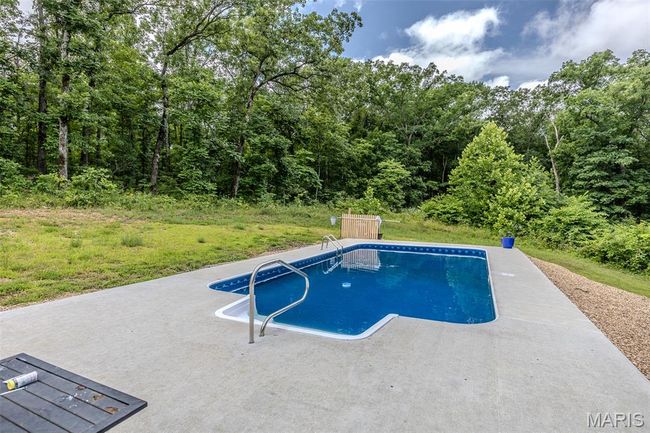 Swimming pool with a patio area and a wooded view | Image 54
