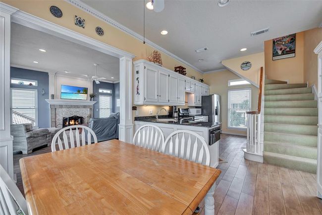 Kitchen & Dining Combo is thoughtfully designed space brings together the kitchen and dining area with ease, featuring white cabinetry, granite countertops, and wood-look tile flooring. Ideal for casual meals, entertaining, or enjoying the natural light pouring in from every angle. | Image 11