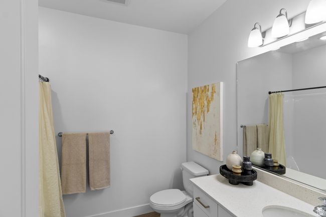 Bathroom with toilet, curtained shower, vanity, baseboards, and visible vents | Image 17