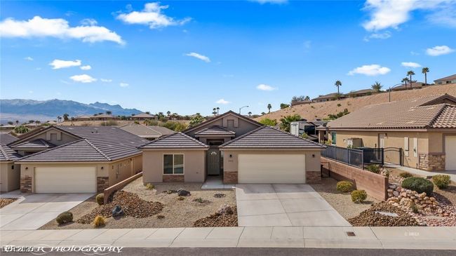 Single story home featuring stone siding, stucco siding, driveway, and fence | Image 61