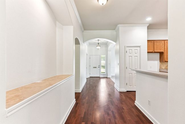 Corridor featuring high ceilings and open to the kitchen. Nice niche for artwork | Image 16