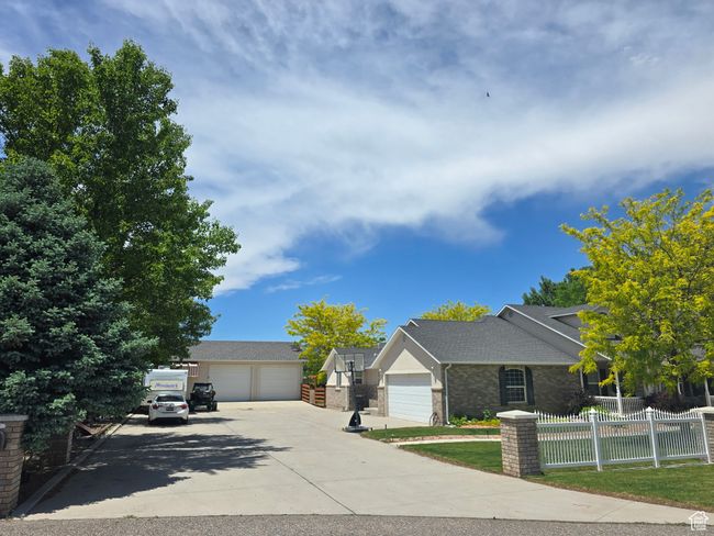 View of front of house featuring a detached garage, brick siding, and roof with shingles | Image 54