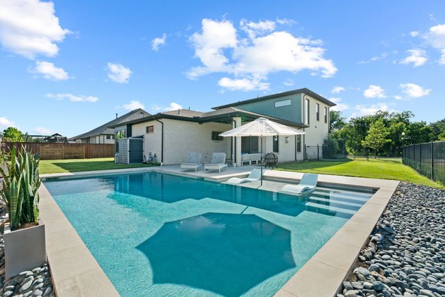 View of swimming pool with a fenced backyard and a patio | Image 36