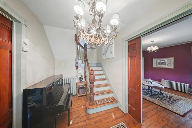 Stairway featuring a chandelier, radiator heating unit, and hardwood / wood-style flooring | Image 20