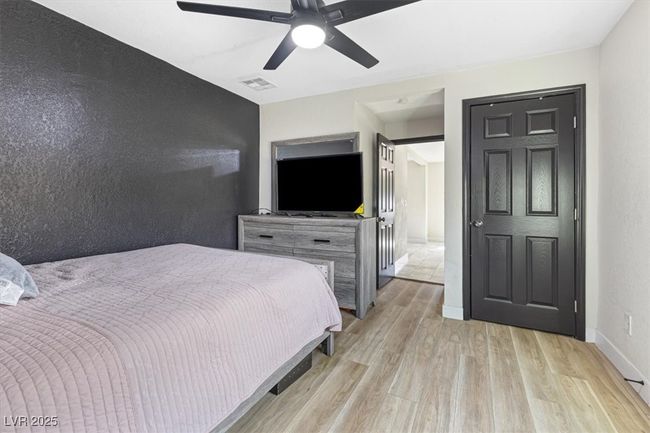 Bedroom with visible vents, light wood-style flooring, baseboards, and ceiling fan | Image 17