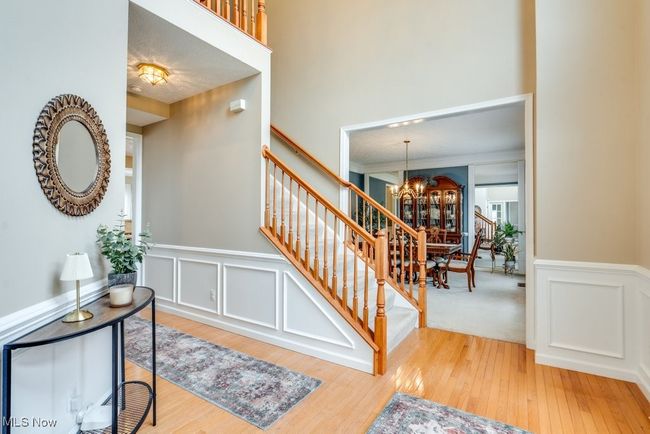 Entryway featuring a chandelier, stairway, wood finished floors, wainscoting, and a decorative wall | Image 11