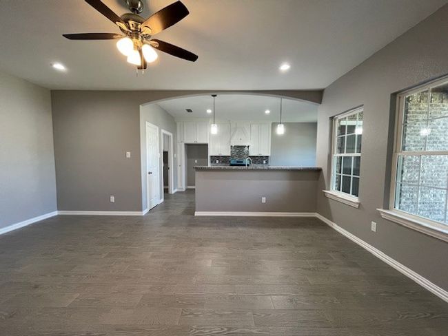 Facing the kitchen with arched entry, wood-style floors, recessed lighting, white cabinetry, and baseboards | Image 5