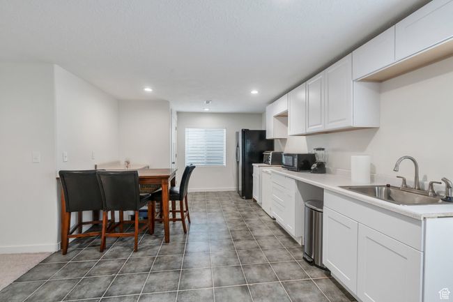 Kitchen featuring freestanding refrigerator, white cabinetry, recessed lighting, and light countertops | Image 15