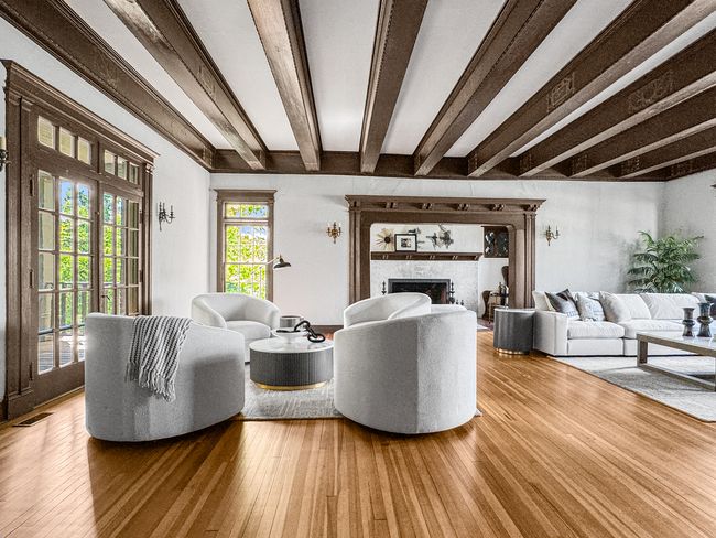The expansive living room features hand-carved bea | Image 5
