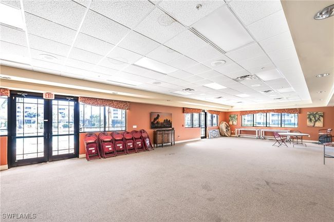 Community room featuring a paneled ceiling, carpet flooring, and a wealth of natural light | Image 24
