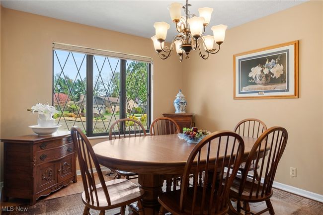 Dining space with baseboards and a notable chandelier | Image 9