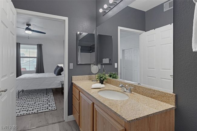 Bathroom featuring visible vents, vanity, wood finished floors, a ceiling fan, and ensuite​​‌​​​​‌​​‌‌​‌‌​​​‌‌​​‌‌​‌​​​​​‌ bath | Image 22