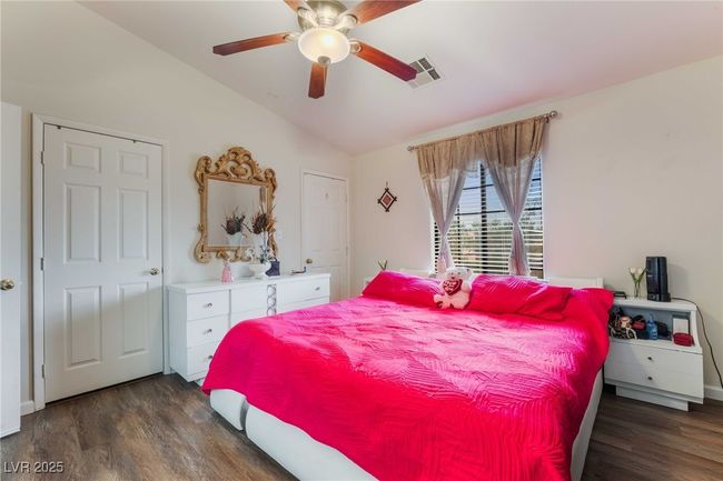 Bedroom featuring lofted ceiling, wood finished floors, visible vents, and a ceiling fan | Image 21