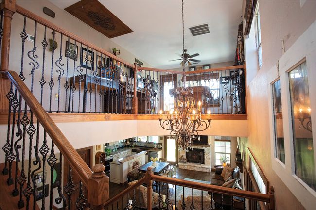 Stairs with a stone fireplace, a ceiling fan, a towering ceiling, and a​​‌​​​​‌​​‌‌​‌‌​​​‌‌​​‌‌​‌​​​​​‌ chandelier | Image 15
