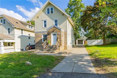 View of property featuring an outdoor structure, a garage, and a front yard | Image 1