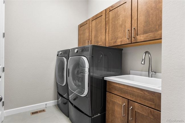 Main floor laundry room with utility sink and closet storage | Image 33