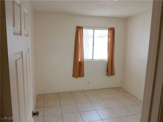Empty room featuring light tile patterned floors and a textured ceiling | Image 10