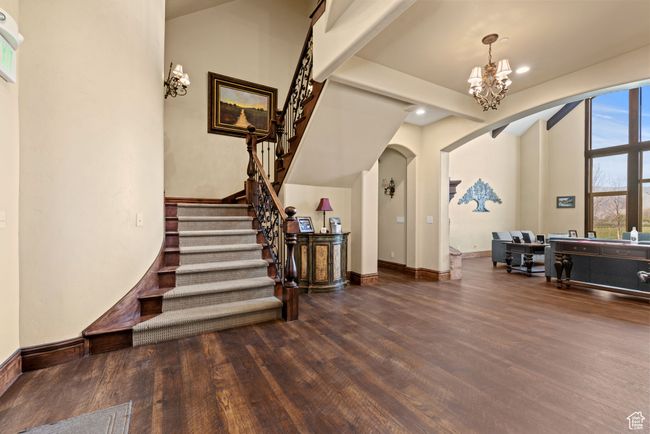 Foyer entrance featuring stairway, arched walkways, a notable chandelier, and wood finished floors | Image 15