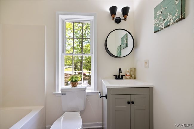 Bathroom with a bath, toilet, and vanity | Image 30