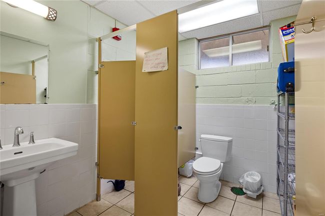 Full bath featuring tile patterned flooring, curtained shower, tile walls, and toilet | Image 22