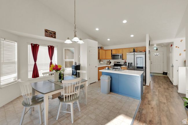 Kitchen with appliances with stainless steel finishes, light countertops, recessed lighting, hanging light fixtures, and a center island with sink | Image 8