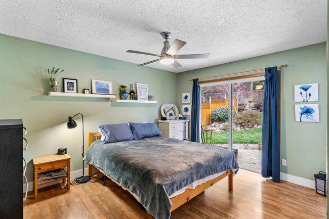Bedroom featuring baseboards, a textured ceiling, access to exterior, ceiling fan, and wood finished floors | Image 17