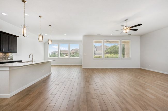 Kitchen with open floor plan, light countertops, light wood-type tile flooring, backsplash | Image 15
