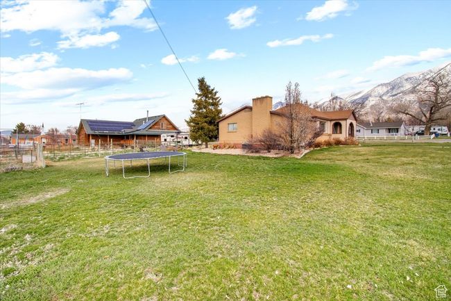 View of yard featuring fence, a trampoline, and a mountain view | Image 16