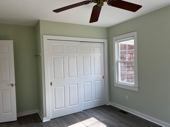 Unfurnished bedroom featuring dark wood-style floors, baseboards, visible vents, and a closet | Image 7