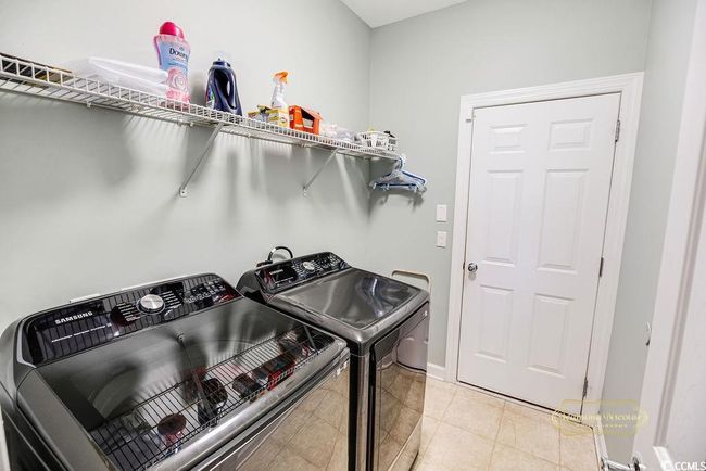 Laundry area featuring washer and dryer and light tile patterned flooring | Image 27