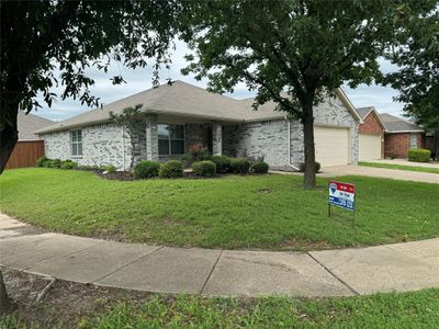 Ranch-style house featuring a garage and a front yard | Image 1