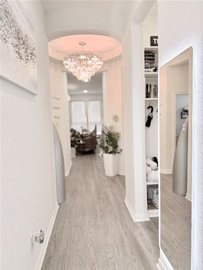 Hallway featuring wood finished floors, arched walkways, and a chandelier | Image 13