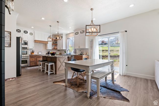 Dining area with light wood-type flooring, baseboards, recessed lighting, and a chandelier | Image 14