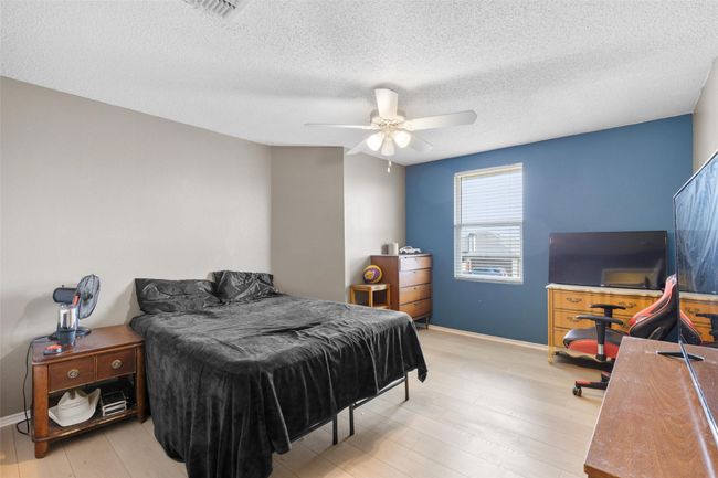 Bedroom featuring wood finished floors, a textured ceiling, and a ceiling fan | Image 27