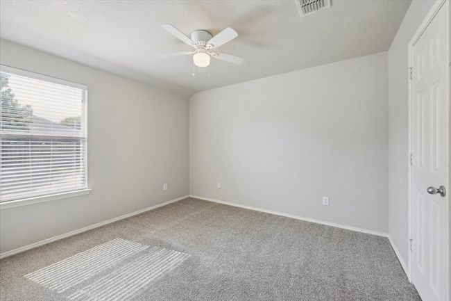 Carpeted spare room featuring a ceiling fan and baseboards | Image 11