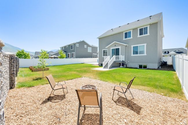 Rear view of house featuring an outdoor fire pit, a fenced backyard, and stucco siding | Image 33