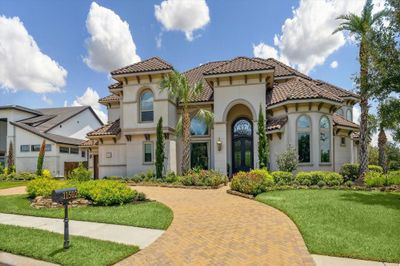 Welcome to this stunning stucco and tile roof cusom home in gated community. Home features stone paved circular direway with extensive landscaping, sparkling pool, and spa, with many upscale and unique features you will love! | Image 1