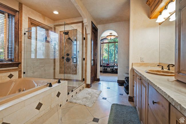 Full bathroom featuring a shower stall, a jetted tub, vanity, and tile patterned flooring | Image 35