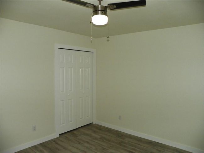 Unfurnished bedroom featuring dark wood finished floors, a closet, and a ceiling fan | Image 19