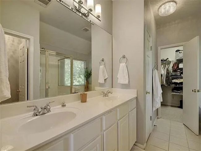 Bathroom featuring a shower stall, double vanity, tile patterned flooring, and a walk in closet | Image 17