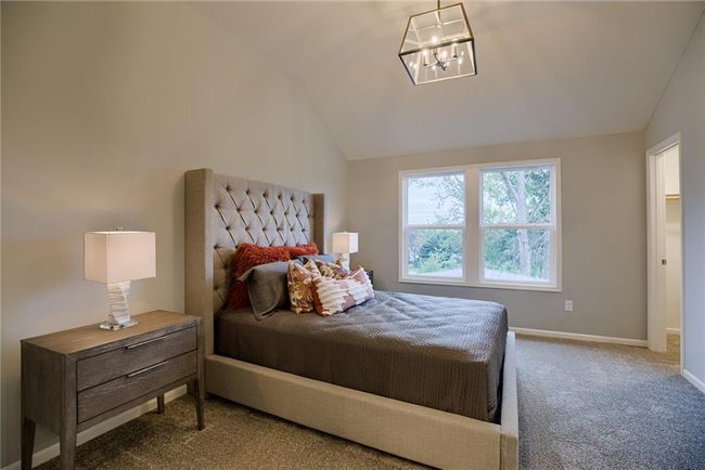 Carpeted bedroom with an inviting chandelier and vaulted ceiling | Image 44