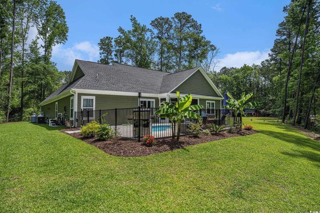 Rear view of house with a shingled roof, a yard, and a patio area | Image 37