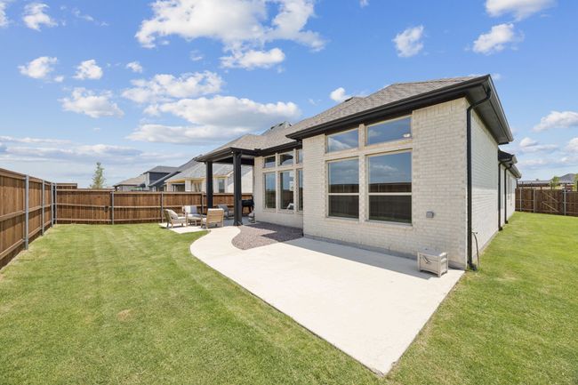 Rear view of house featuring brick siding, a patio area, an outdoor living space, and roof with shingles | Image 27