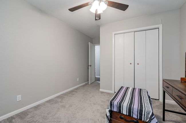 Unfurnished bedroom with a closet, ceiling fan, and light colored carpet | Image 6
